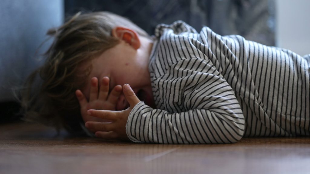Child crying on the floor having a tantrum